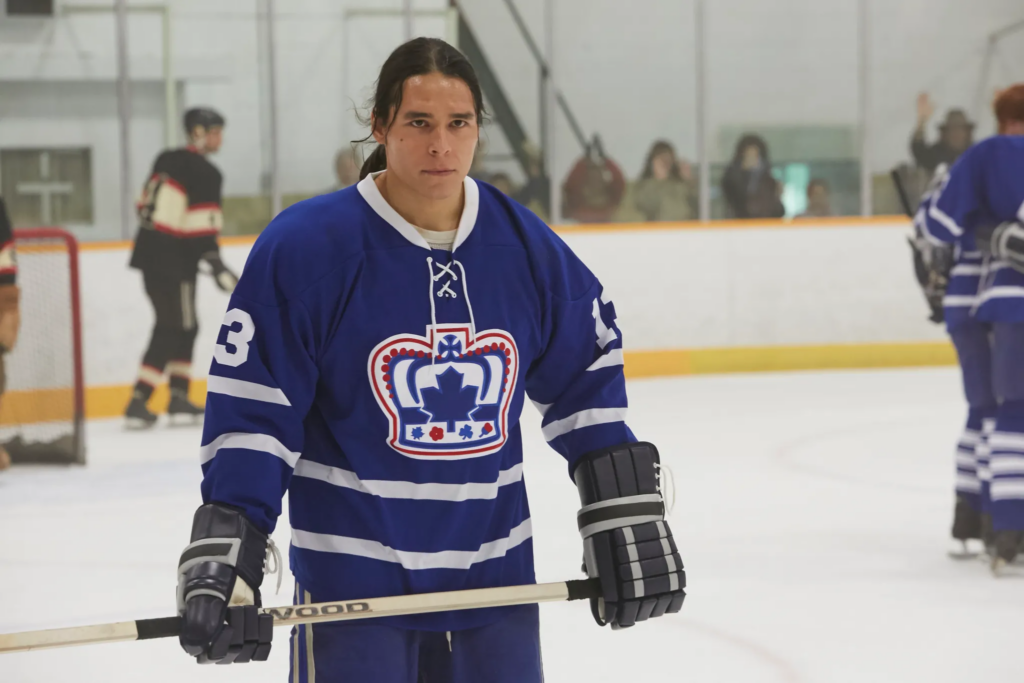 an indigenous hockey player starring at his components