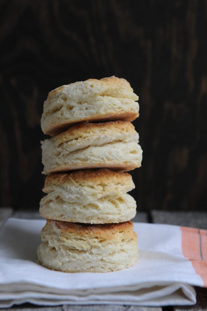 Fluffy buttermilk biscuits are resting on a towel. (side dish)