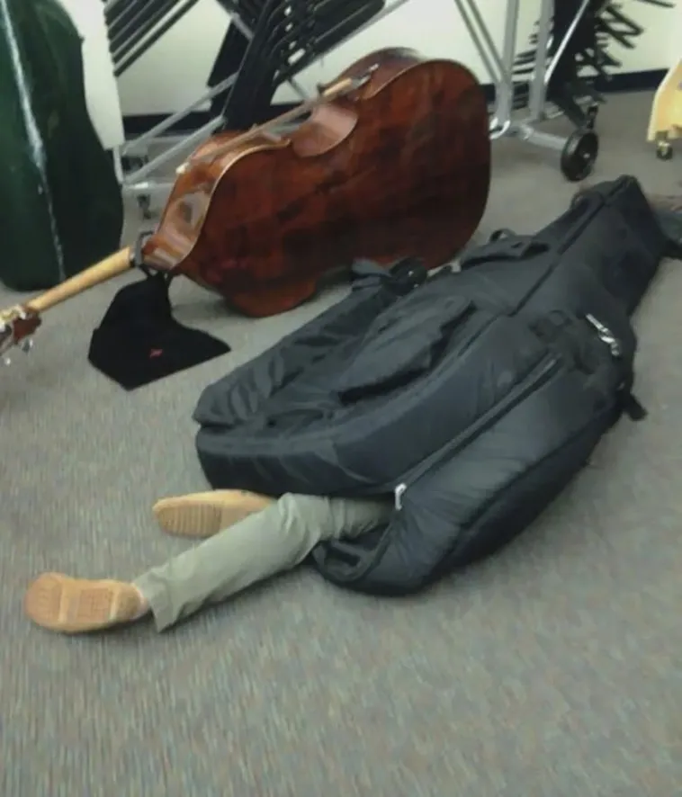 a student sleeping in an instrument bag