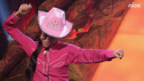 Liza Koshy in a pink cowboy hat gesturing throwing a lasso.