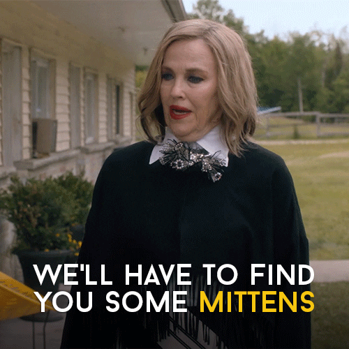 The character Moira Rose from Schitt's Creek gestures sarcascially with the text "We'll have to find you some mittens" seen below.
