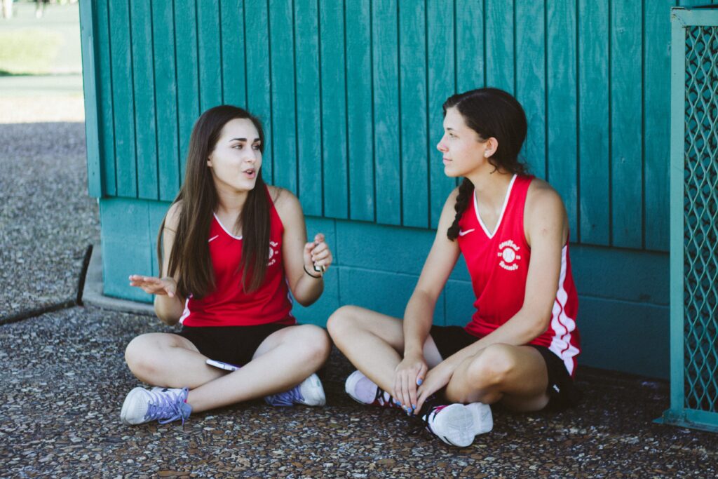 Two women in a college team talking to one another.
