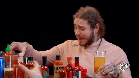 Post Malone drinking milk with hot sauce in front of him.