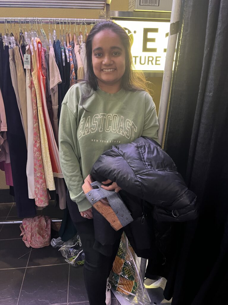 A student shopper holding some recycled clothing from the event. 
