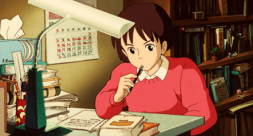 a girl in a red sweater studying hard at her desk.
