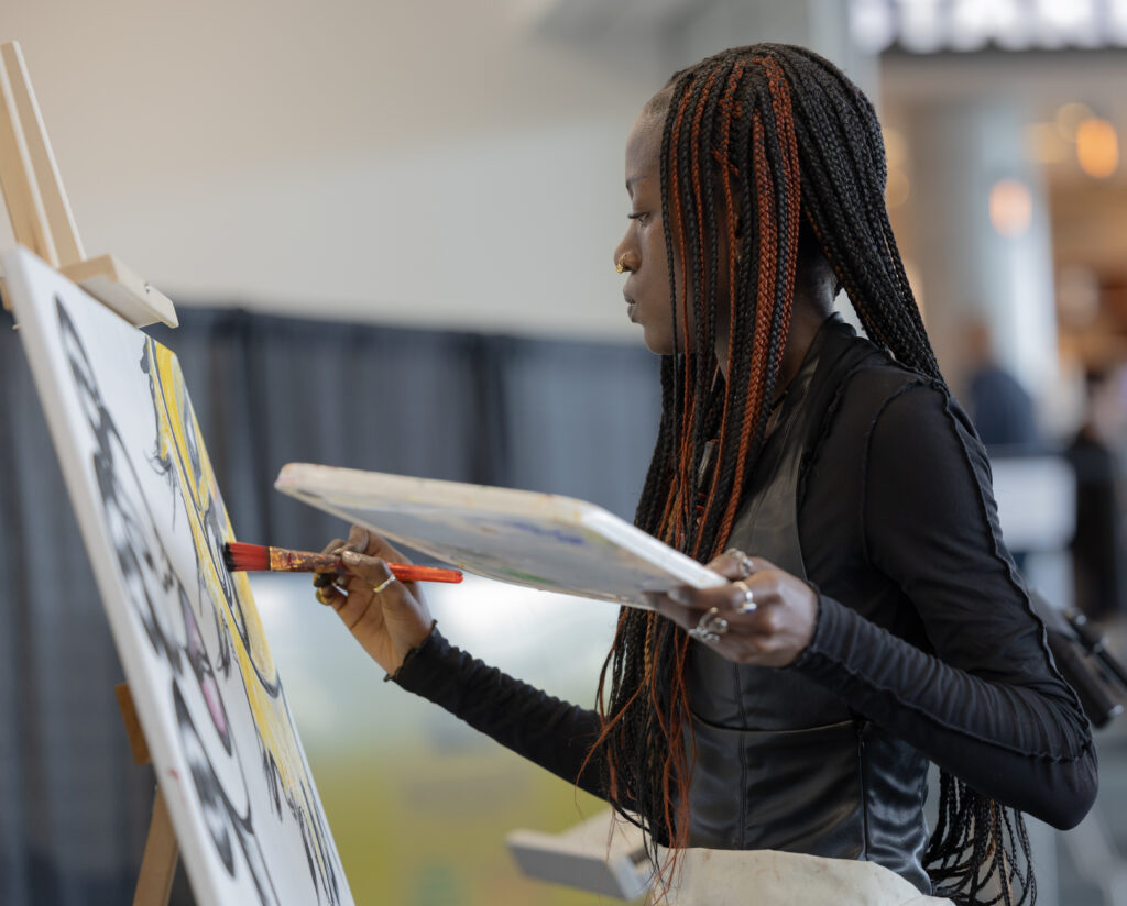 Black woman painting on Black Excellence Conference.