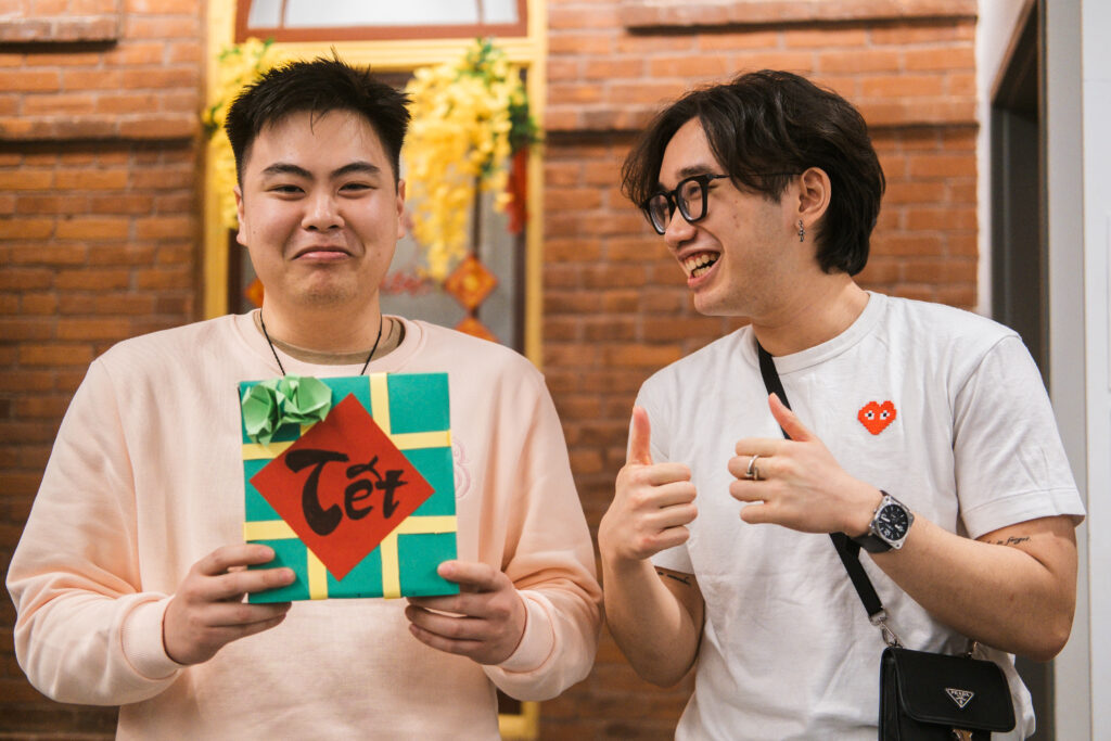 a man holding Chung cake beside a man who is laughing