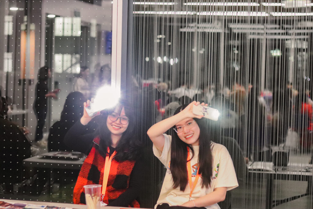 two girls holding phone with flashlight