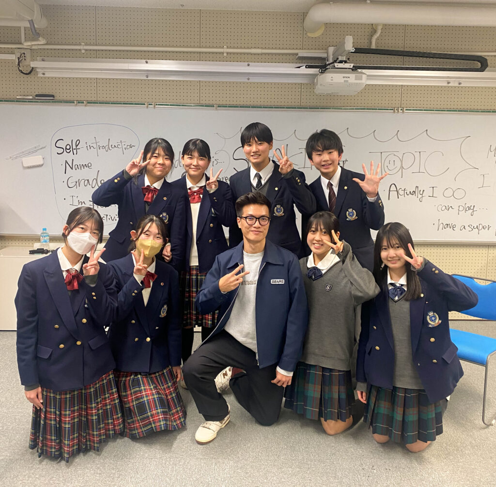 a group of Japan students take picture with a foreigner