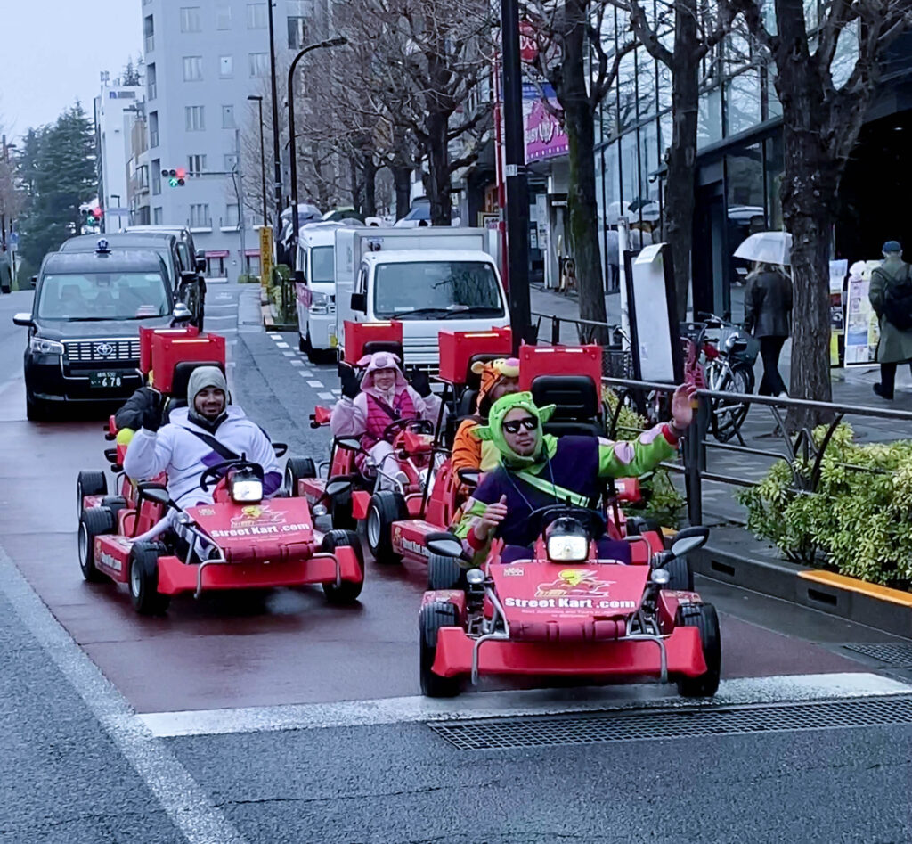 a group of foreigners driving Mario Kart