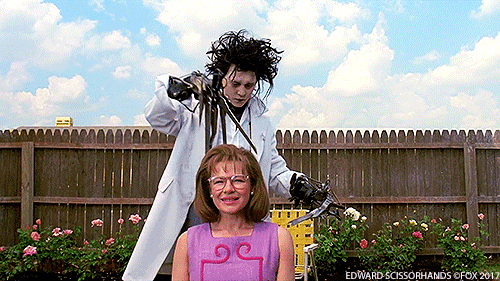 Character Edward Scissorhands trims a woman's hair.