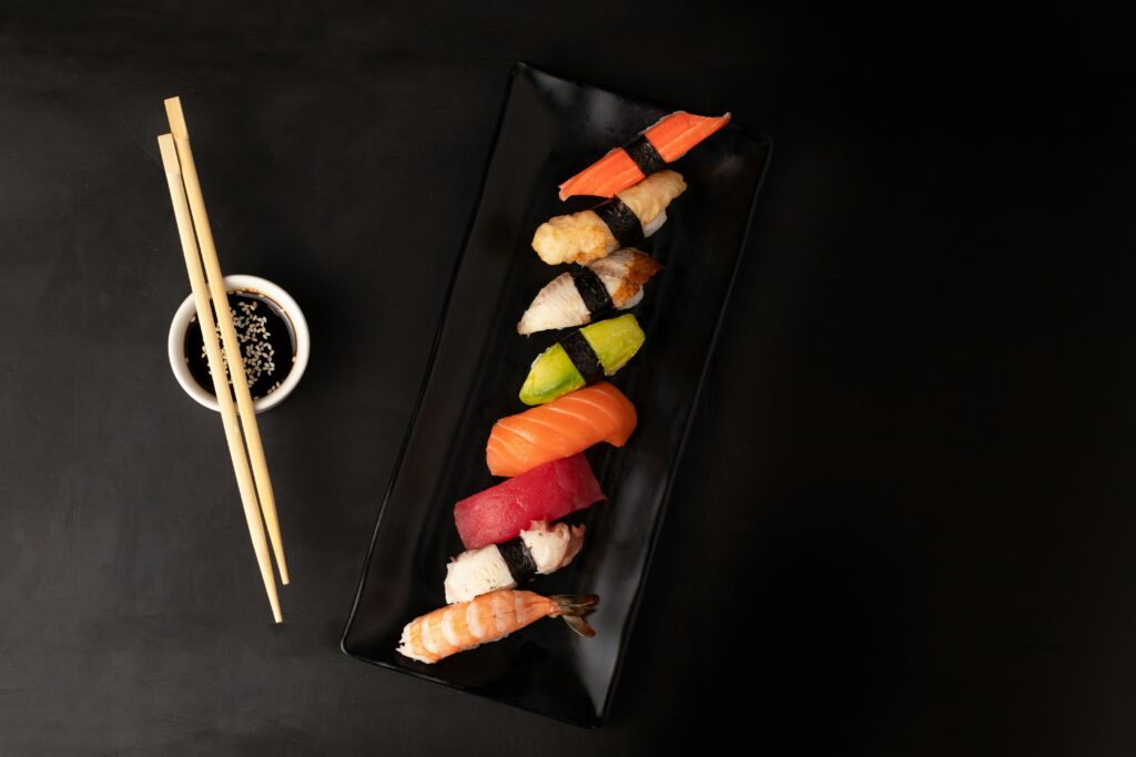 Picture of sushi on black square plate in authentic restaurants.