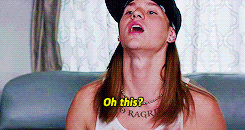 A man displaying a tattoo on his chest saying "No Ragrets."