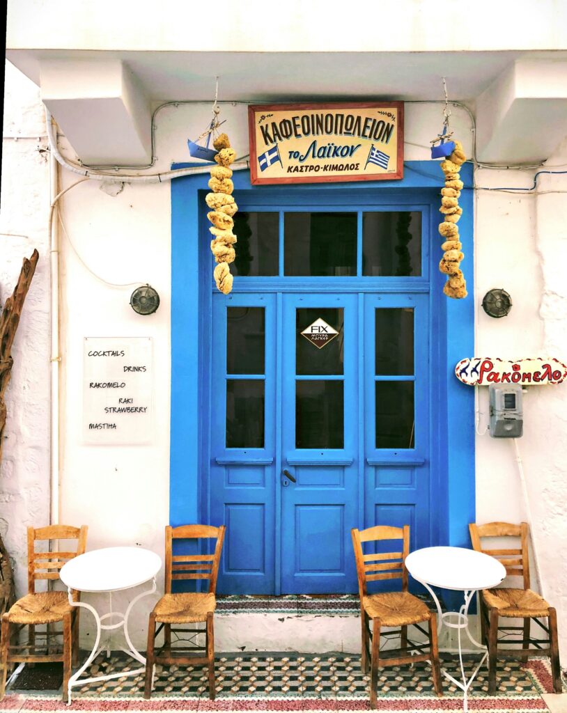 A picture of a blue wooden door with Greek signage