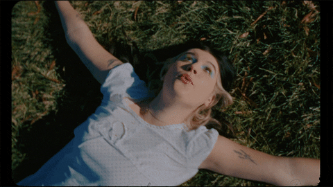 GIF of a person enjoying their time laying down in the grass.