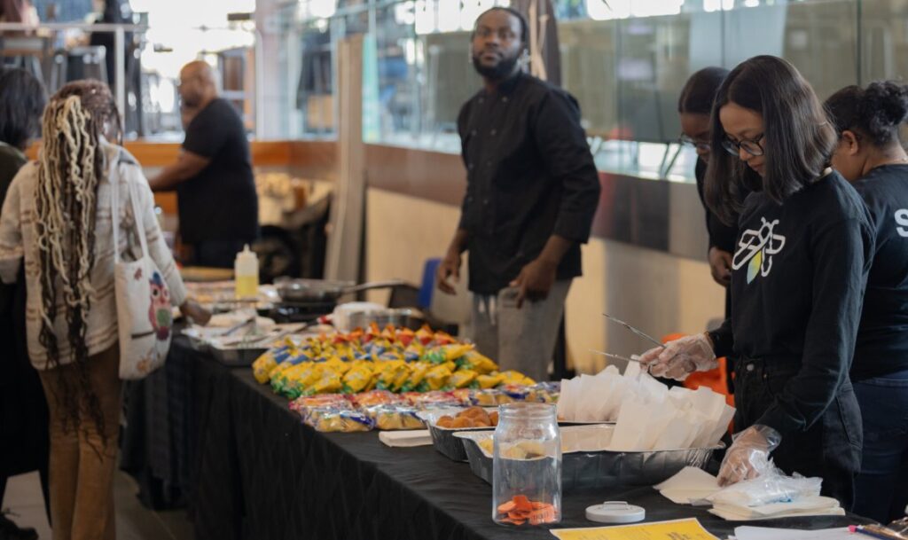 IGNITE staff handing out food laid out on tables to students.