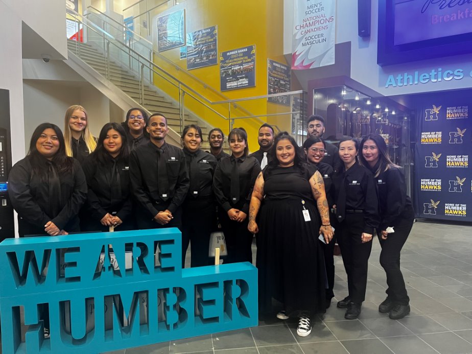 A group of students in black outfits smiling.