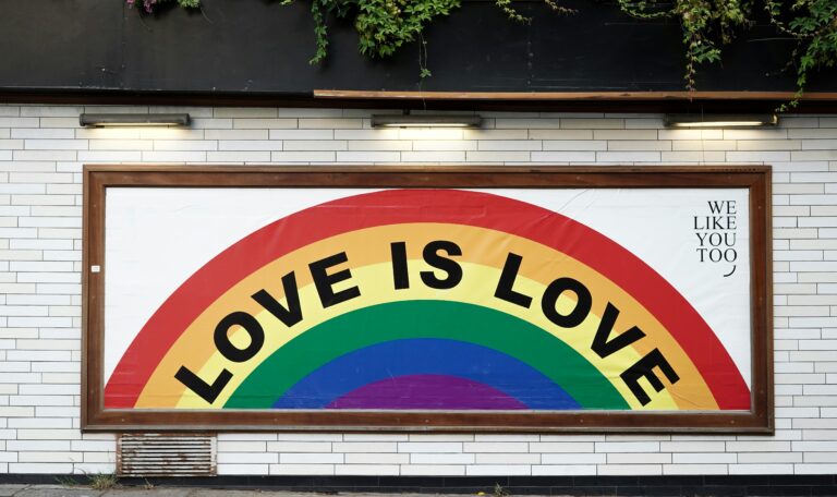 A billboard with a rainbow and "Love is Love" text.