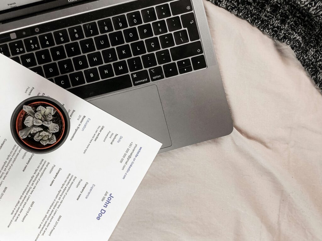 Picture of a resume printed on top of a MacBook Pro.