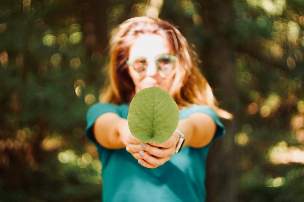 Picture of a woman holding a leaf relating to sustainability.