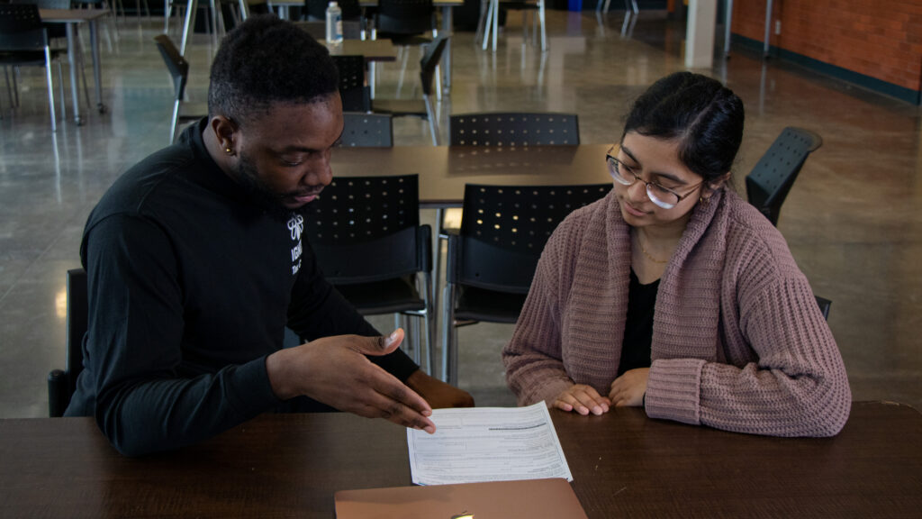 A Tax Clinic volunteer helping a student fill out their taxes.