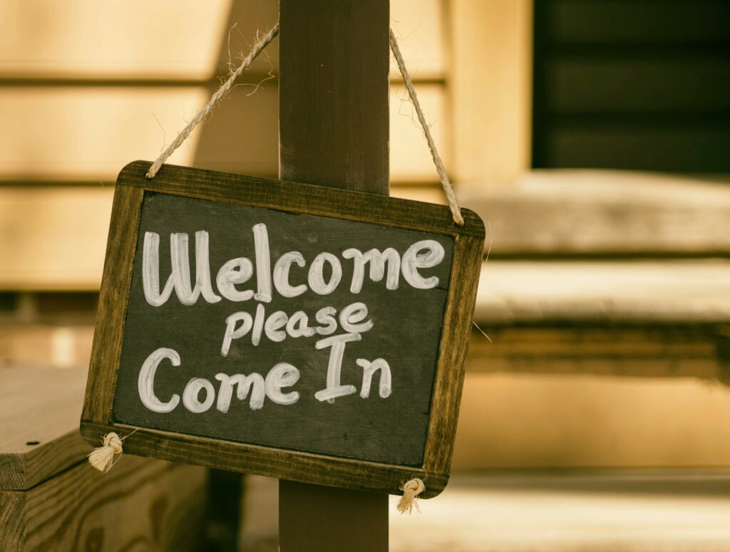 A welcome chalkboard sign that reads “Welcome please come in.”