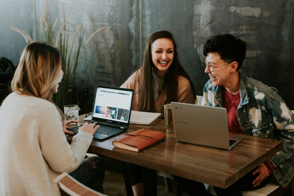 Three people sitting at a table and laughing together.