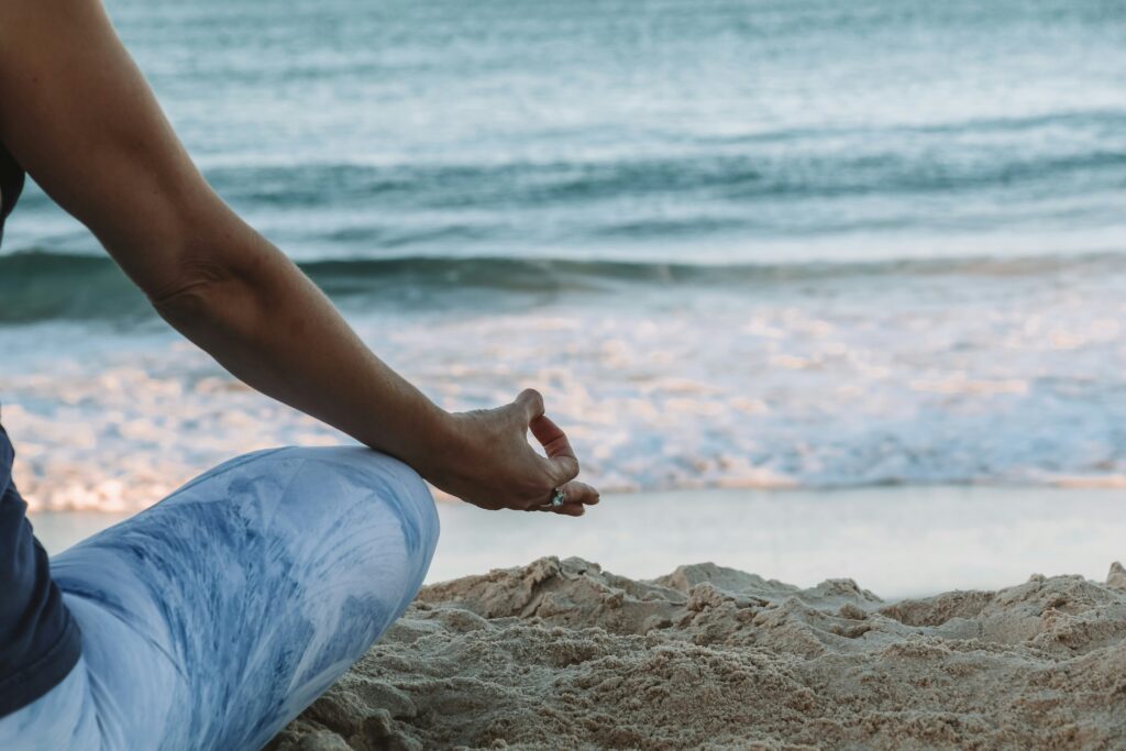 A person meditating on a beach.