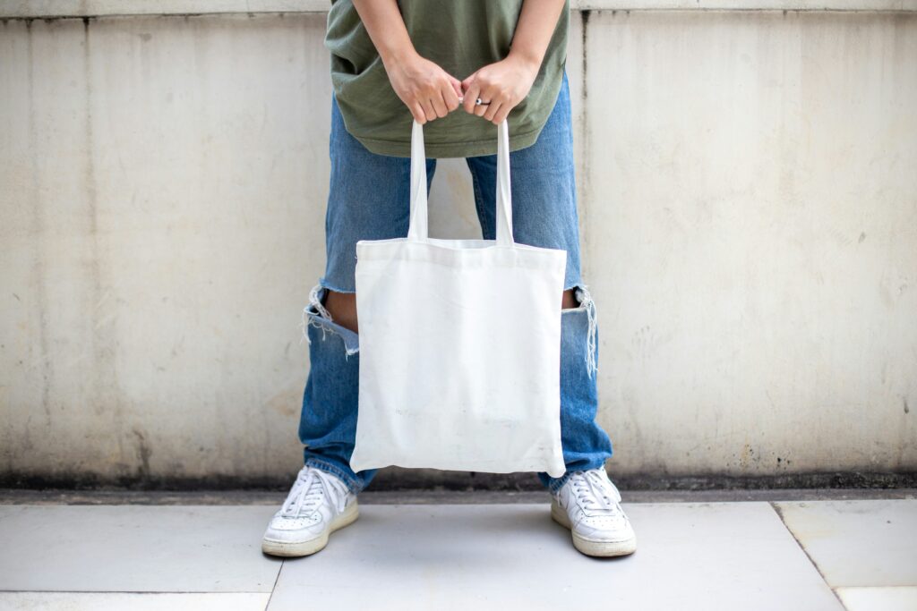 Picture of a person holding a white tote bag.