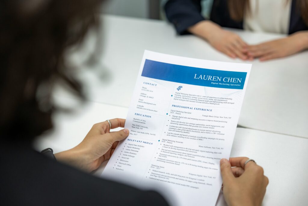 A close-up view of a person reviewing the resume of an applicant during a job interview.