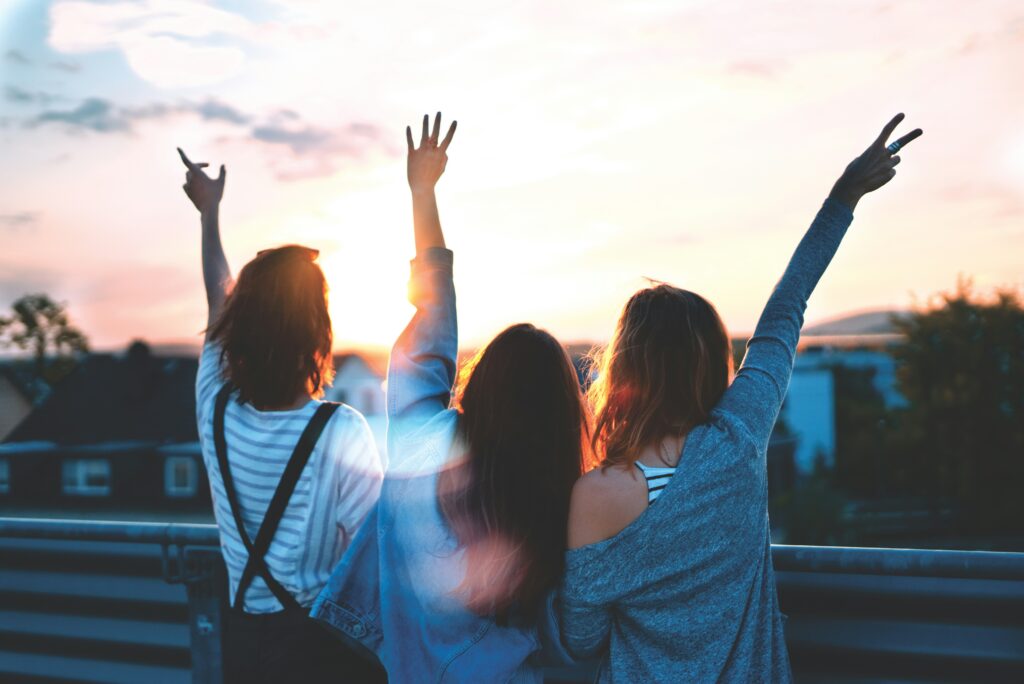 Three women lifting their hands.