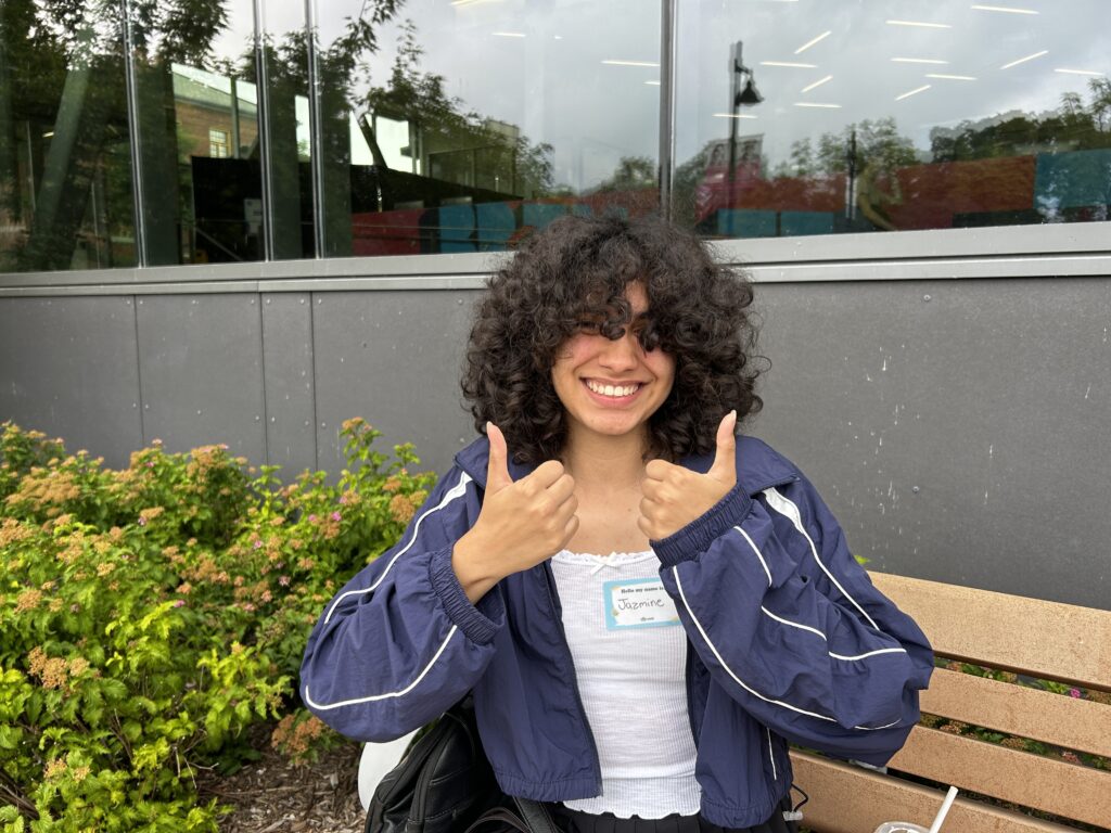 Humber student Jazmine De Sousa smiles at the camera as she does a two-thumbs-up pose.