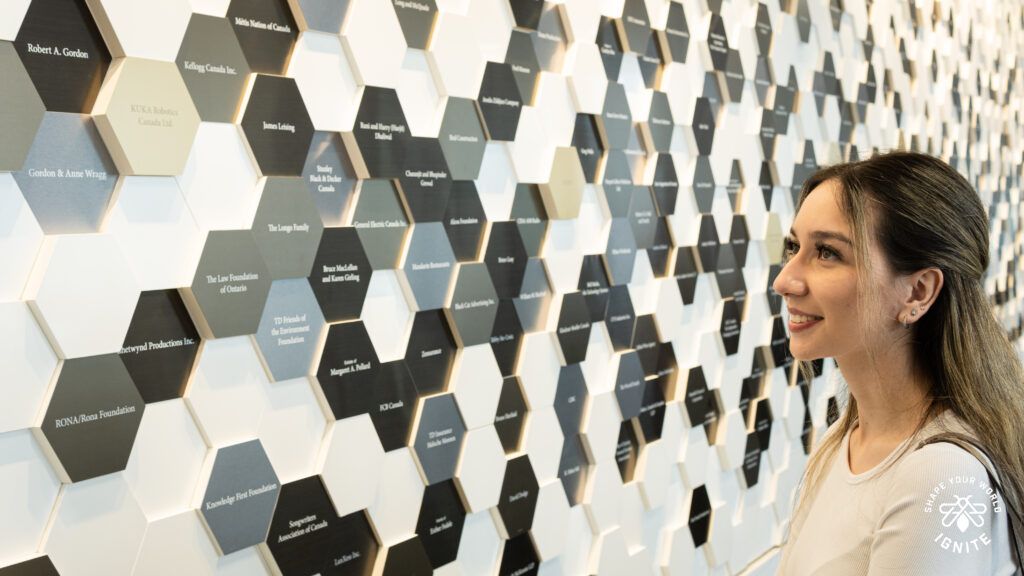 A woman looking at scholarship names at the Humber College North campus.