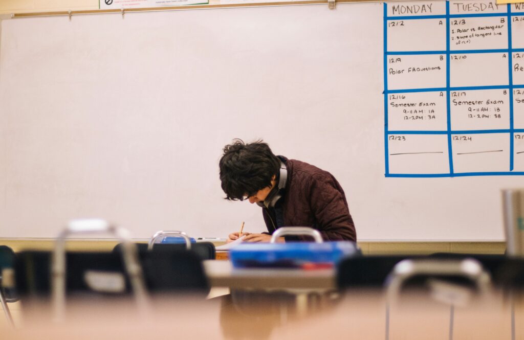 A student doing homework in a classroom.