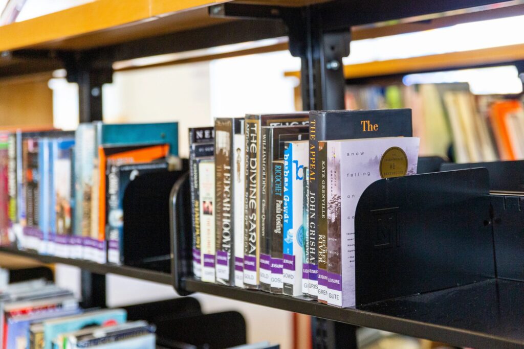 A collection of books on a library shelf. 