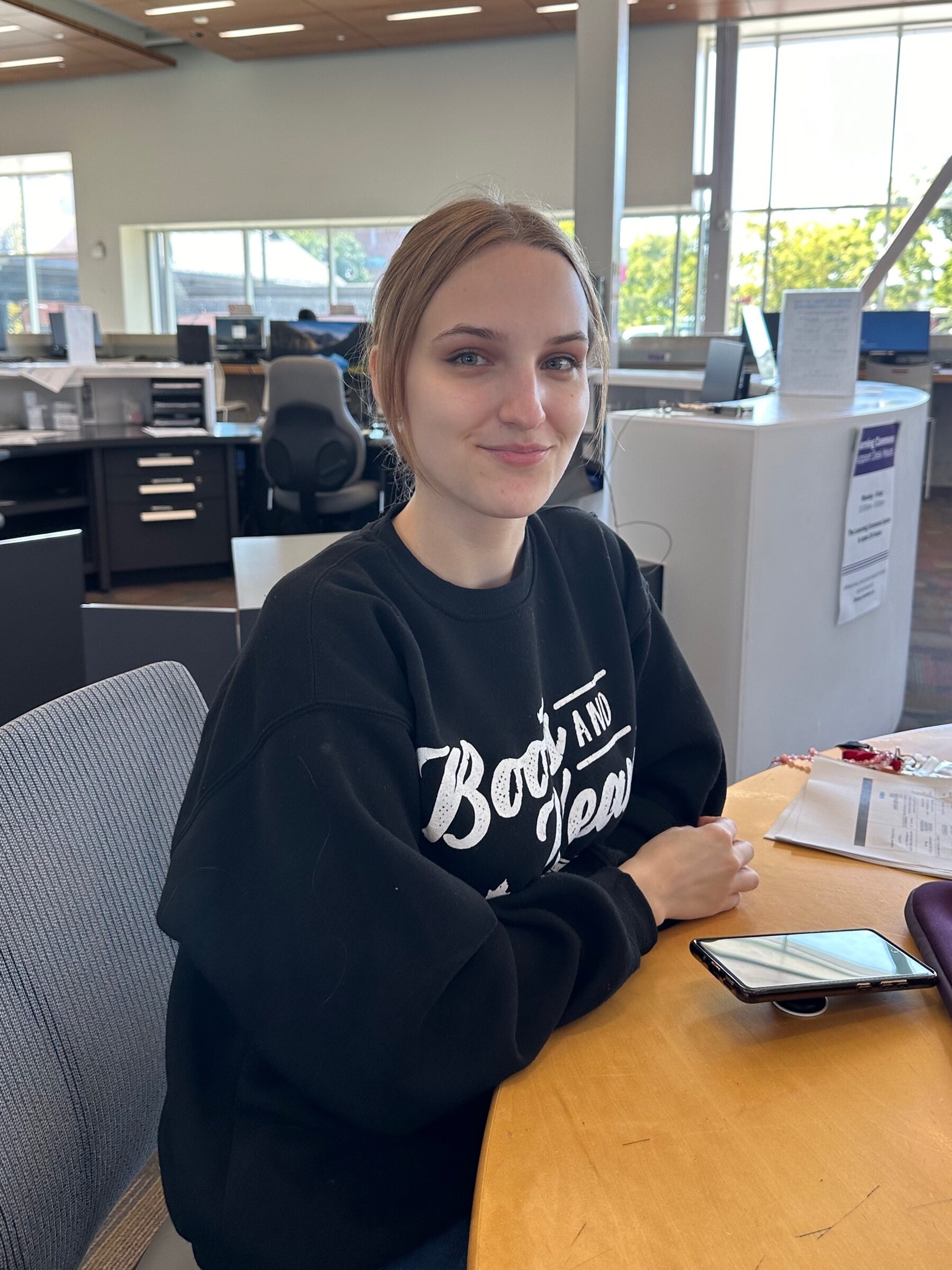 Headshot of student Larisa Vollering sitting at a table in the Lakeshore Commons located on the Lakeshore campus.