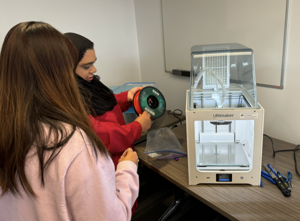 Picture of people setting up the 3D printer.