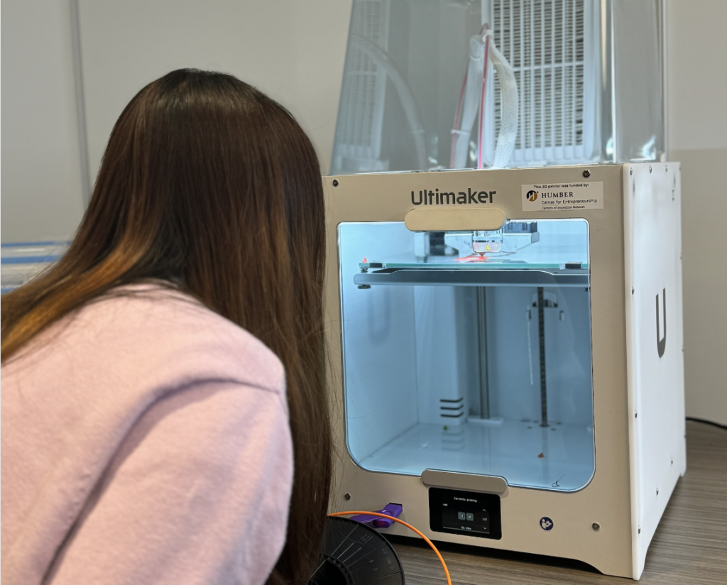 Picture of a girl waiting at the 3D print to finish.