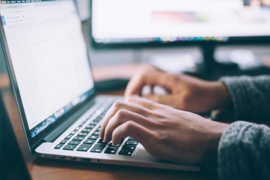 A close up shot of hands typing in a laptop.