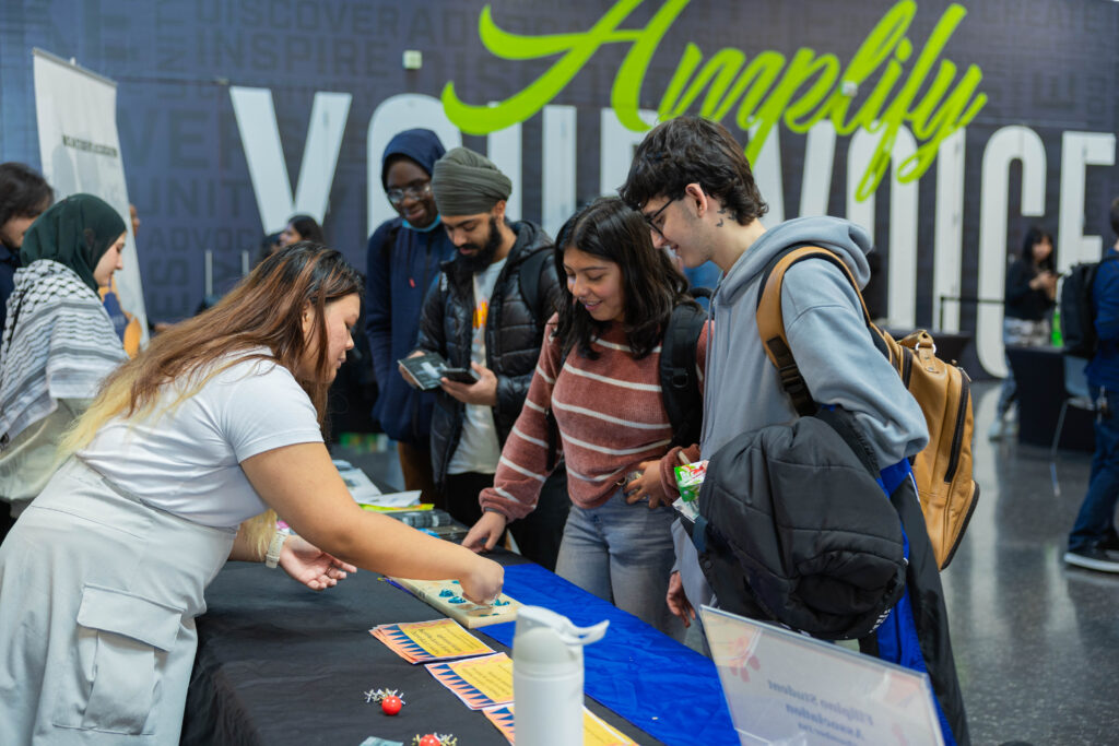 Students crowding around a table at club fair