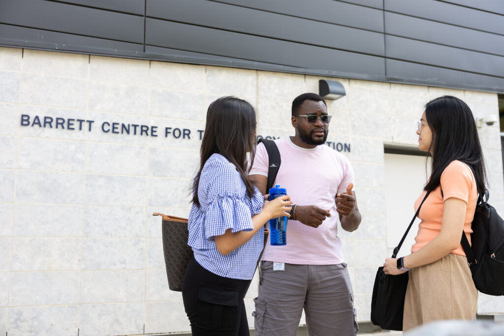 Three students talking in front of the Barret Centre for Technology Innovation at the North campus.