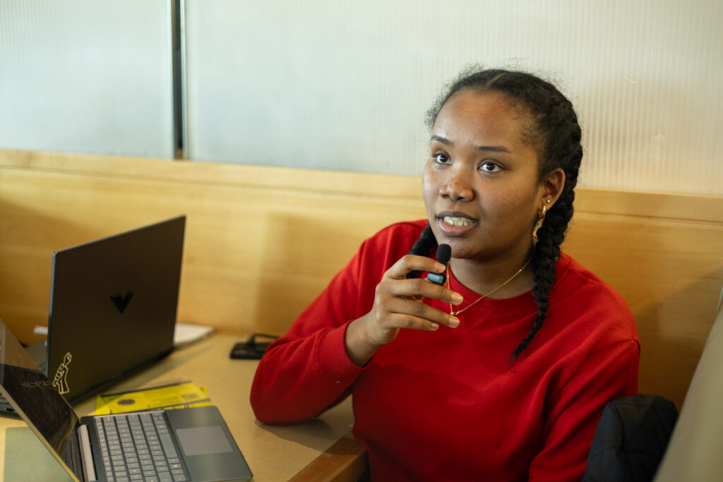 A woman is speaking while holding a microphone. 