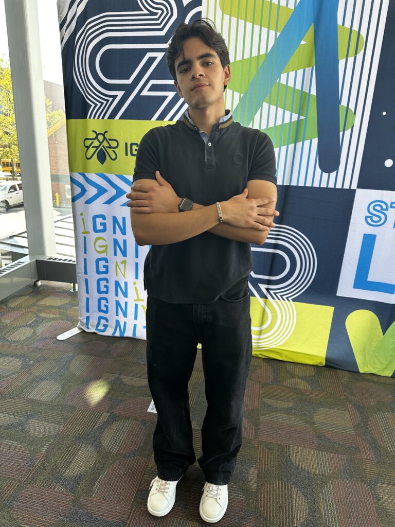 A student with his arms crossed posing for a picture. Street Styles.