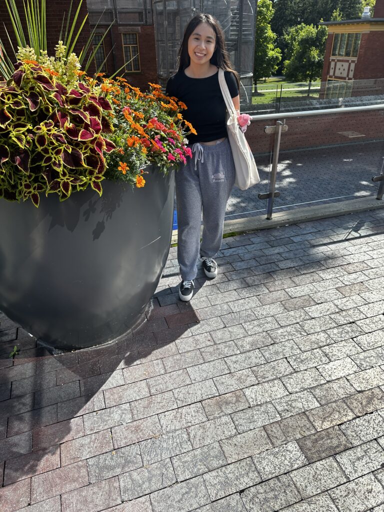 A student posing with a tote bag for a picture. Street Styles.