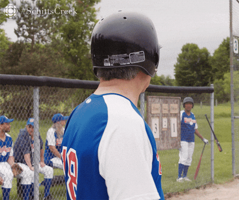Johnny from the TV show Schitts Creek, wearing a blue and white baseball uniform, telling someone off screen to "Always be ready."