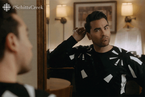 David from Schitts Creek looking at himself up and down in a stand up mirror then saying Alright. 