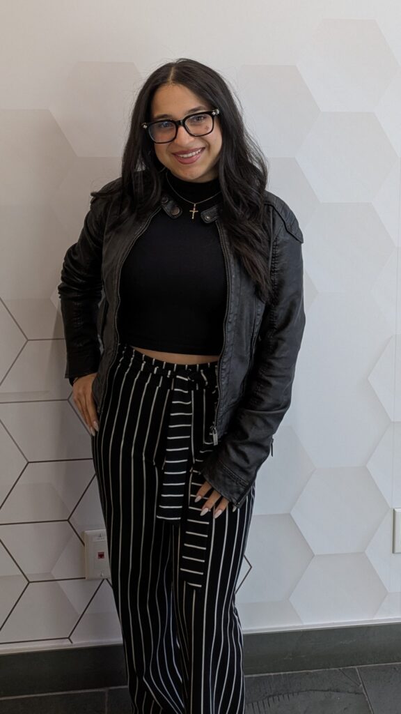 Sabrina D'Agnone wearing the office siren trend. A leather jacket and black and white pants with lines. 