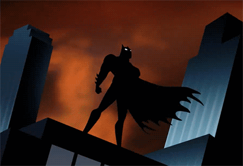 Batman standing on top of a builidng as lightning flashes in the background