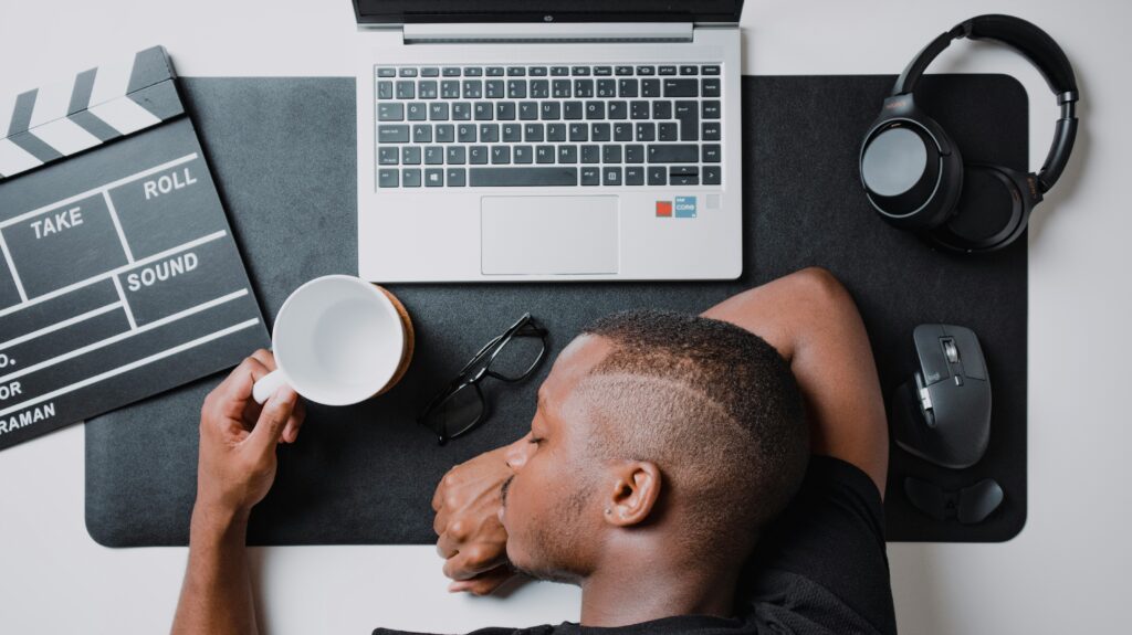 a man sitting a a desk with a laptop and headphones 