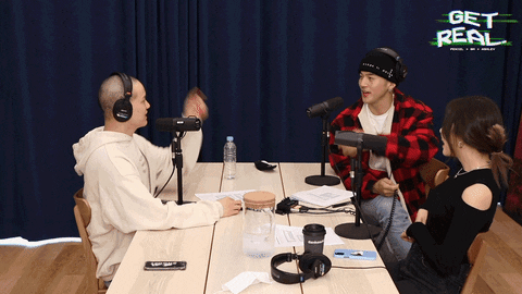 Three people talking while two of them point at each other and laugh